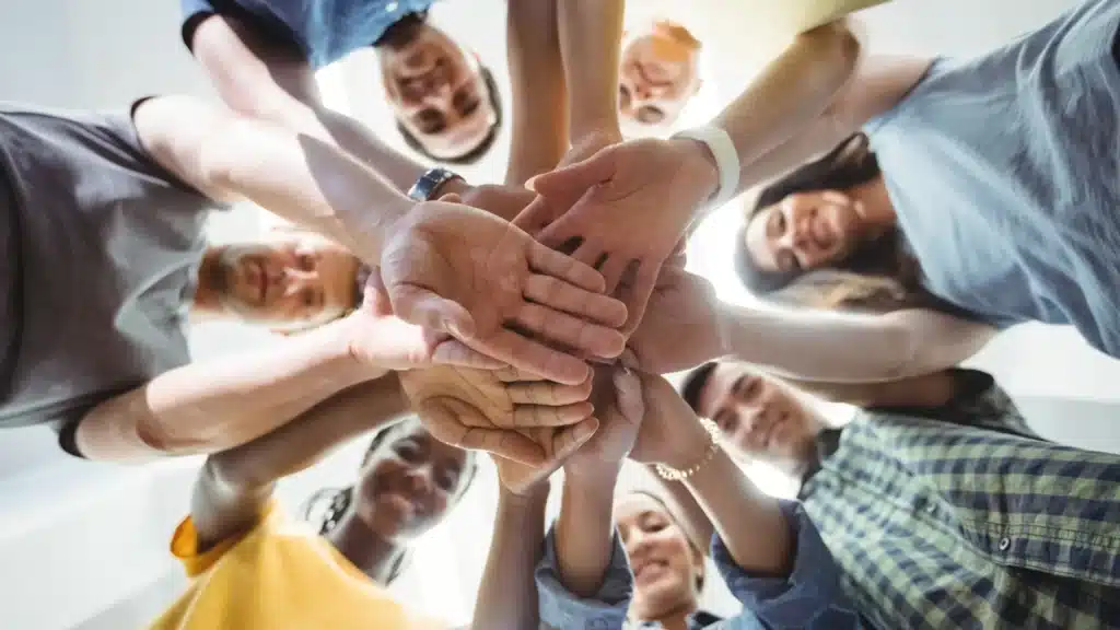 Groupe de personnes joignant leurs mains au centre en signe d'unité et de collaboration