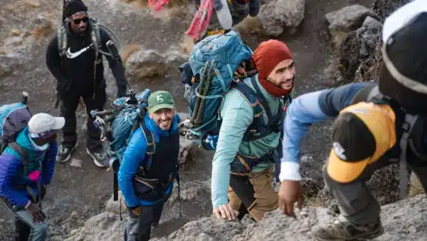 Un groupe de randonneurs escalade une montagne rocheuse, uni par la détermination et la camaraderie.